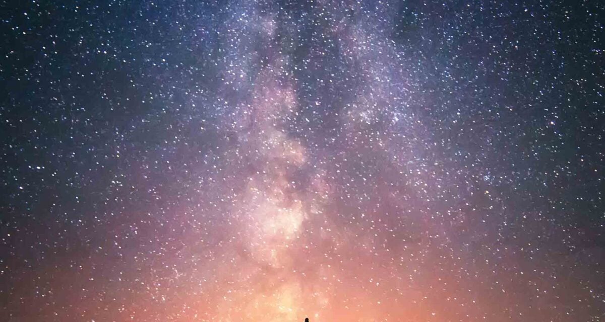 Photo of a starry sky with silhouettes of people