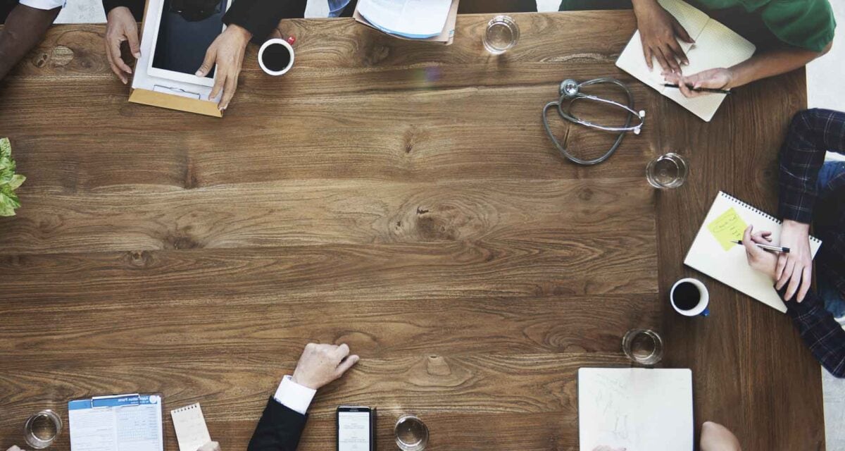Photo of a doctors discussing at a wooden table