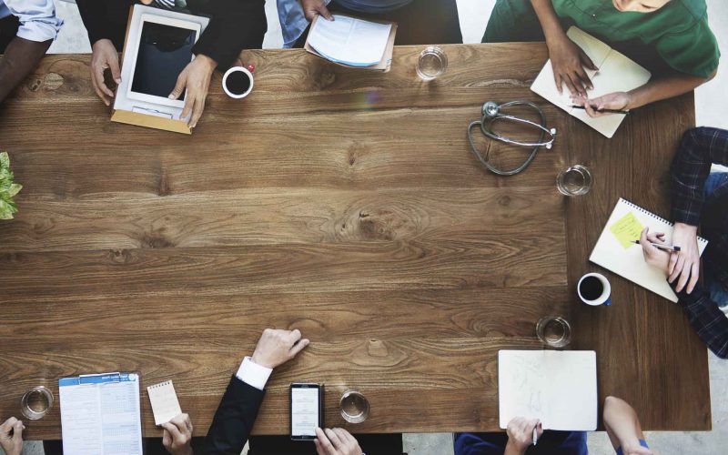 Photo of a doctors discussing at a wooden table
