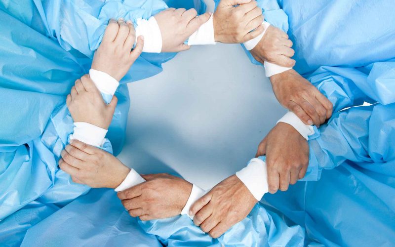 Photo of hands of surgeons forming a circle