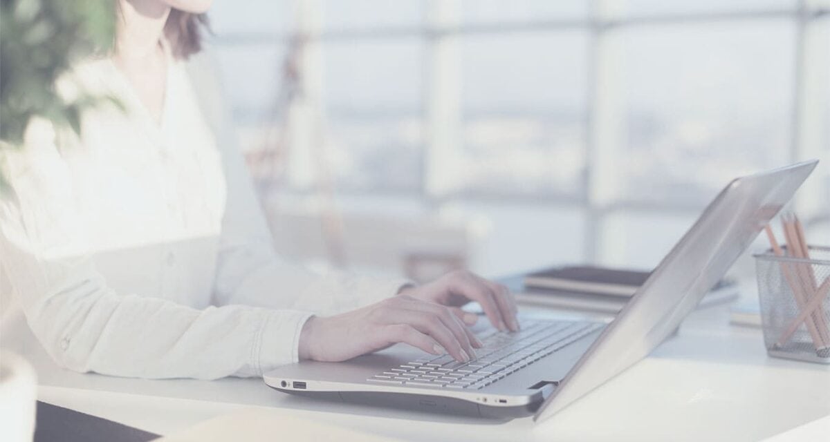 Female blogger typing on a laptop