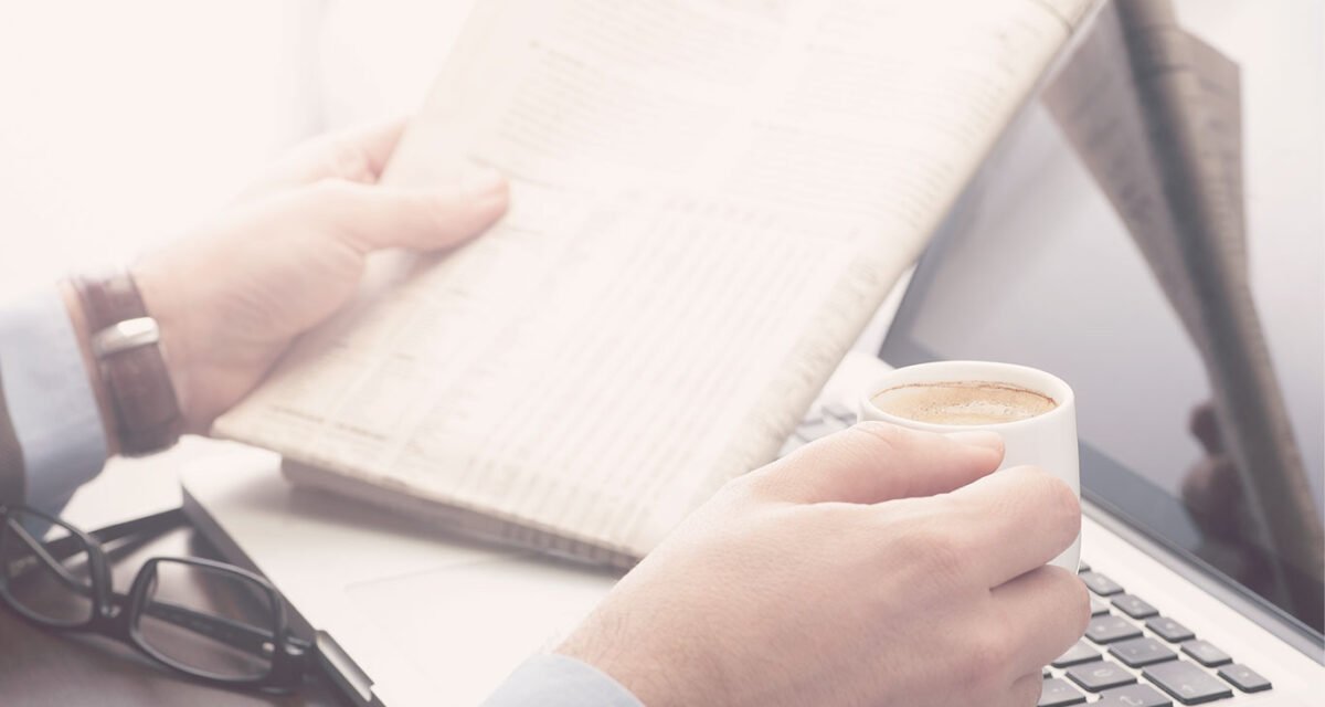 Person with coffee and newspaper