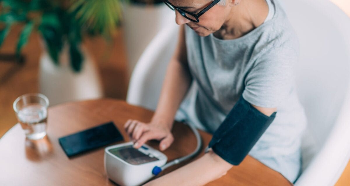 woman measures blood pressure at home