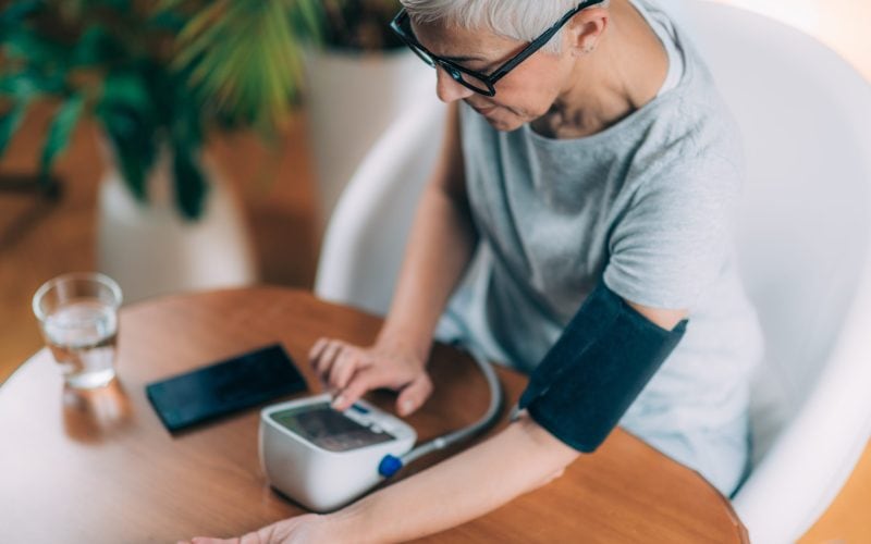 woman measures blood pressure at home