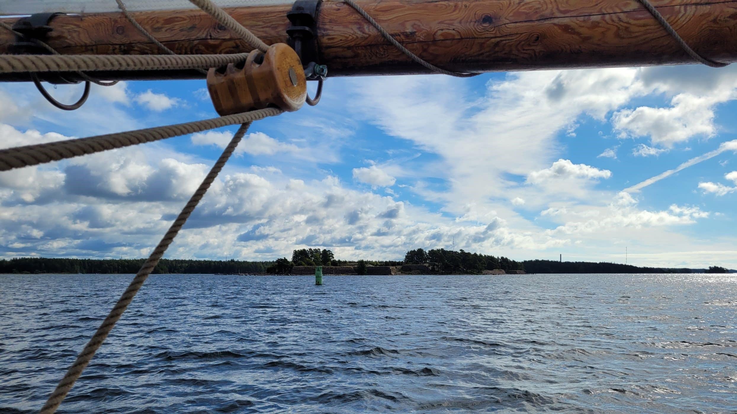 Purjelaivanpuomin alta näkyy saari